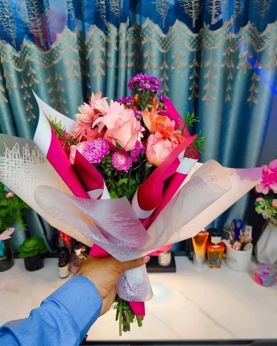 A cheerful hand-held bouquet mixing pink and purple flowers in a natural, garden-fresh style — handcrafted by Bloom & Beyond in Lahore